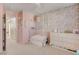 Bedroom with pink accent wall, white furniture, and decorative floral wallpaper at 3232 Romanesque Art Ave, Henderson, NV 89044