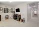 Neutral bonus room with wall mounted TV, carpet flooring and hallway leading to other rooms at 3232 Romanesque Art Ave, Henderson, NV 89044