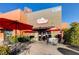 Outdoor seating area with red umbrellas at Romano Italian Deli & Cafe at 3232 Romanesque Art Ave, Henderson, NV 89044