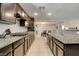 Long kitchen featuring granite countertops, dark wood cabinets, and stainless steel appliances at 3232 Romanesque Art Ave, Henderson, NV 89044
