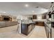 Open-concept kitchen with island, granite countertops, and dark wood cabinetry at 3232 Romanesque Art Ave, Henderson, NV 89044
