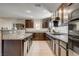 Galley kitchen featuring granite countertops, dark wood cabinets, and stainless steel appliances at 3232 Romanesque Art Ave, Henderson, NV 89044