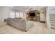 Spacious living room featuring a comfortable sofa, a media center, and a staircase leading to the upper level at 3232 Romanesque Art Ave, Henderson, NV 89044