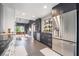 Modern kitchen featuring stainless steel appliances, dark cabinets, and a dining area with natural light at 3306 Brookfield Dr, Las Vegas, NV 89120