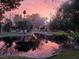 Scenic view of a tranquil pond reflecting a beautiful sunset sky with mature trees around the house at 3306 Brookfield Dr, Las Vegas, NV 89120