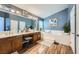 This bathroom boasts double sinks, a large vanity, a tub, and wood-look flooring at 3728 Granada Gorge Ln, North Las Vegas, NV 89084