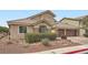Inviting single-story home with three car garage, stone accents, desert landscaping, and a paver driveway at 3728 Granada Gorge Ln, North Las Vegas, NV 89084