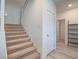 Carpeted staircase with white railing ascending to the upper level with neutral walls and nearby door at 3783 Canis Minor Ln # 6104, Henderson, NV 89052