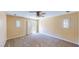 Spacious carpeted bedroom featuring natural light, ceiling fan, and neutral tones at 3820 Ice Storm Ct, Las Vegas, NV 89129