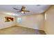 View of the living room with tan carpet, ceiling fan, and an open view into the kitchen at 3820 Ice Storm Ct, Las Vegas, NV 89129