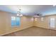 Spacious carpeted living room featuring ample natural light and stylish ceiling fixtures at 3820 Ice Storm Ct, Las Vegas, NV 89129