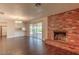 Open living room with a cozy brick fireplace, hardwood floors, and sliding glass doors to the backyard at 4000 Twain Ave, Las Vegas, NV 89121