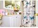 This bathroom has white cabinetry, a large mirror, and a shower with a patterned curtain at 4145 Plumtree St, Las Vegas, NV 89115
