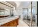 Modern bathroom features a double sink vanity and a glass enclosed walk-in shower with stone tile at 4620 Standing Bluff Way, Las Vegas, NV 89130