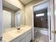 Well-lit bathroom featuring a large mirror and white single sink vanity at 5359 Harvest Breeze Rd, Las Vegas, NV 89118