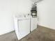 Side view of a washer and dryer in a garage with a water heater and cement floor at 5359 Harvest Breeze Rd, Las Vegas, NV 89118