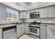 Bright kitchen features stainless steel appliances, gray cabinets, and eat in dining space at 584 Sellers Pl, Henderson, NV 89011