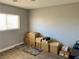 Neutral-toned bedroom with window and boxes on a modern wood floor at 6182 Blue Rapids Ct, Las Vegas, NV 89139
