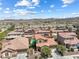 Lovely aerial view of a two-story home with solar panels nestled in a desert community with mountain views at 648 Sunrise Lake Pl, Henderson, NV 89002