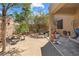 Spacious backyard featuring mature trees, rock landscaping, and a covered patio area at 648 Sunrise Lake Pl, Henderson, NV 89002