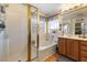 This bathroom has a glass enclosed shower and large soaking tub under a window at 648 Sunrise Lake Pl, Henderson, NV 89002