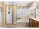 Bright bathroom with a glass enclosed shower and large soaking tub under a window at 648 Sunrise Lake Pl, Henderson, NV 89002