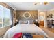 Bright bedroom boasts a wooden accent wall, comfy bed, and ensuite bathroom entrance at 648 Sunrise Lake Pl, Henderson, NV 89002