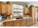 Well-lit kitchen features wood cabinetry, stone countertops, stainless steel appliances, and a view of the backyard at 648 Sunrise Lake Pl, Henderson, NV 89002