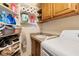 Functional laundry area with shelves, storage, a sink, and a washing machine at 648 Sunrise Lake Pl, Henderson, NV 89002