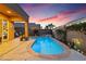 Beautiful backyard pool features a waterfall feature, ambient lighting, and meticulously landscaped garden at 648 Sunrise Lake Pl, Henderson, NV 89002