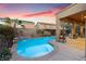 Inviting pool with a tanning ledge, water feature, and landscaped patio under a covered area, perfect for outdoor relaxation at 648 Sunrise Lake Pl, Henderson, NV 89002