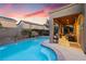 Inviting pool with a tanning ledge, water feature, and landscaped patio under a covered area, perfect for outdoor relaxation at 648 Sunrise Lake Pl, Henderson, NV 89002