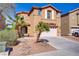 Two-story beige home has a landscaped front yard with desert landscaping and well-maintained lawn at 6480 Chebec St, North Las Vegas, NV 89084