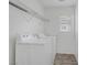Clean laundry area featuring a washer, dryer, and overhead storage shelves at 6480 Chebec St, North Las Vegas, NV 89084