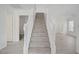 Carpeted staircase with white banister leading to the upper level at 6480 Chebec St, North Las Vegas, NV 89084