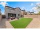 Backyard featuring artificial grass, gravel, and a patio seating area at 7132 Sayonara Vista St, North Las Vegas, NV 89084