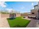 Landscaped backyard features artificial turf, patio with seating, and a small trampoline at 7132 Sayonara Vista St, North Las Vegas, NV 89084