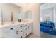 Well-lit bathroom with double sinks, white cabinetry, and a glimpse into the adjacent bedroom at 7132 Sayonara Vista St, North Las Vegas, NV 89084