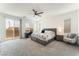 Spacious primary bedroom with gray carpet, a ceiling fan, a king bed, and sliding glass door to balcony at 7132 Sayonara Vista St, North Las Vegas, NV 89084