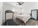 Bright bedroom featuring a treadmill, white bedding, ceiling fan, and a large mirror at 7132 Sayonara Vista St, North Las Vegas, NV 89084