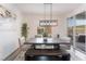 Dining room features a modern chandelier, large windows, and slider door to patio at 7132 Sayonara Vista St, North Las Vegas, NV 89084
