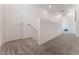 Bright hallway featuring neutral carpet, white walls, staircase, and doors for a clean modern look at 7132 Sayonara Vista St, North Las Vegas, NV 89084
