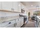 Bright kitchen boasts stainless appliances, white cabinets, and beautiful granite counters at 7132 Sayonara Vista St, North Las Vegas, NV 89084