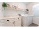 Laundry room with front loading washer and dryer, storage cabinets and white counter at 7132 Sayonara Vista St, North Las Vegas, NV 89084