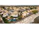 Aerial view showing a residential area with well-kept homes, solar panels, and a community waterway at 730 Rusty Spur Dr, Henderson, NV 89014
