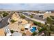 Aerial view of a home with a pool and patio, complemented by neighboring properties and a nearby waterway at 730 Rusty Spur Dr, Henderson, NV 89014