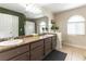 Bathroom features double vanity with granite countertop, tiled floors, and a window for natural light at 730 Rusty Spur Dr, Henderson, NV 89014