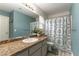 Bathroom showcasing granite countertops, a large mirror, and a patterned shower curtain at 730 Rusty Spur Dr, Henderson, NV 89014