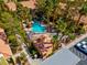 Aerial view of community pool, hot tub, clubhouse, parking, and lush landscaping at 7950 W Flamingo Rd # 1003, Las Vegas, NV 89147