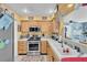 Well-lit kitchen featuring wooden cabinetry, stainless steel appliances, and a double basin sink at 7950 W Flamingo Rd # 1003, Las Vegas, NV 89147